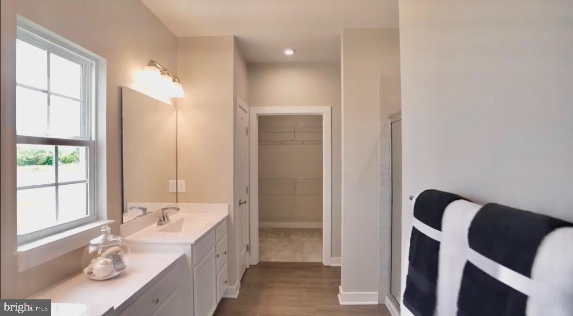 37946 Oneida Way Frankford, DE 19945 - Photo 14 of 29 a bathroom with a granite countertop sink a mirror and a bathtub