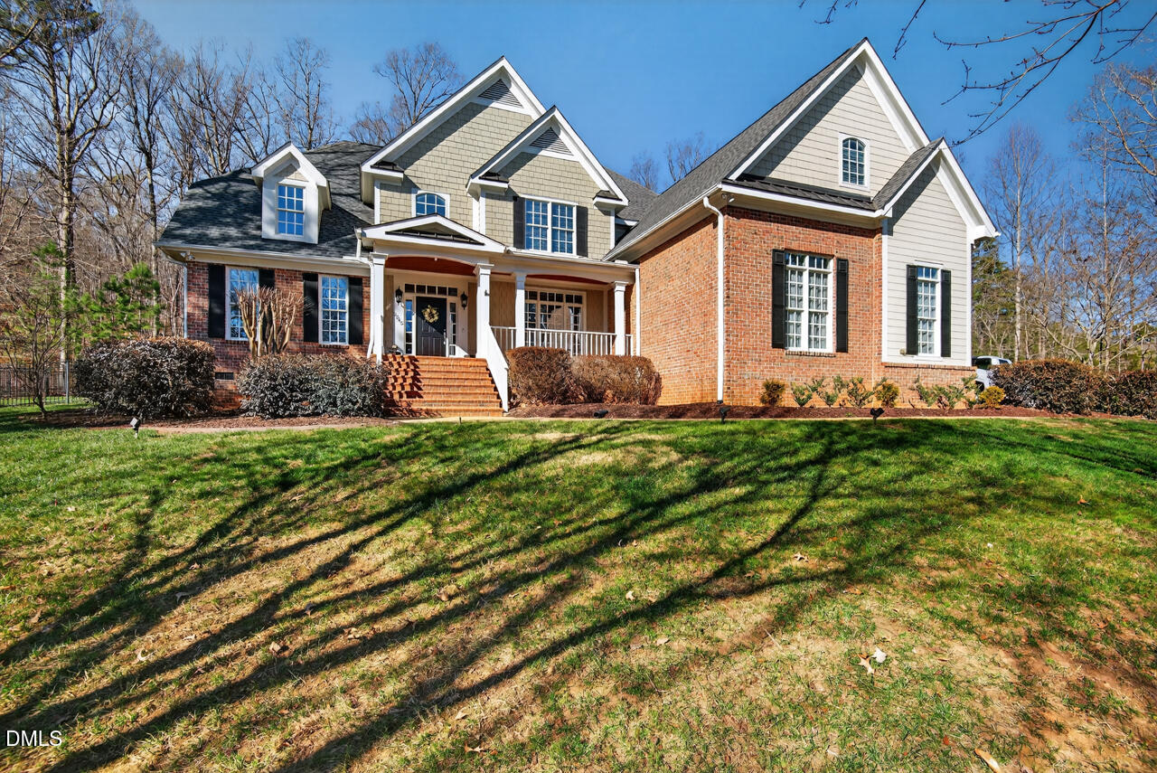 a front view of a house with a yard and trees
