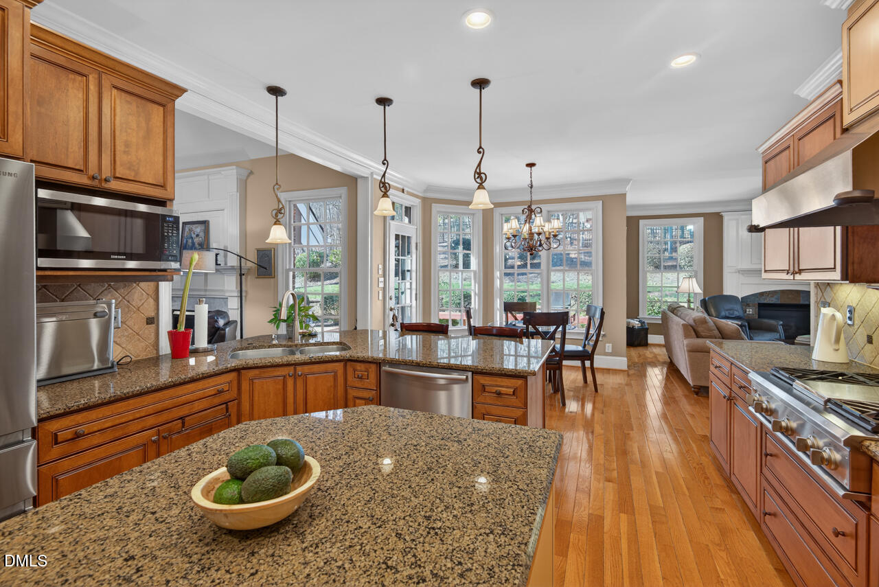 2545 Bittersweet Drive Durham, NC 27705 - Photo 24 of 91 a kitchen with stainless steel appliances granite countertop a stove a sink and a wooden floors