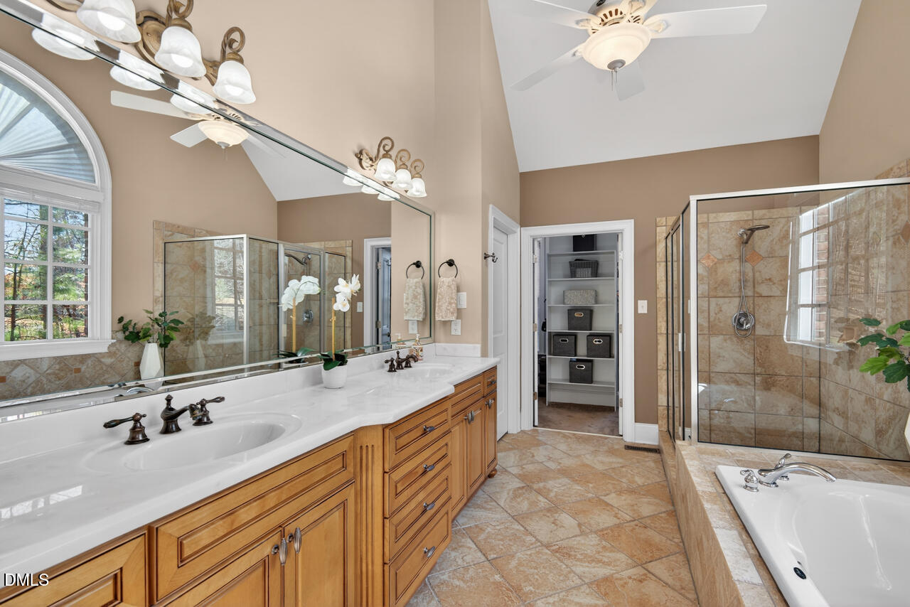 2545 Bittersweet Drive Durham, NC 27705 - Photo 46 of 91 a spacious bathroom with a granite countertop sink a mirror a shower and a bathtub