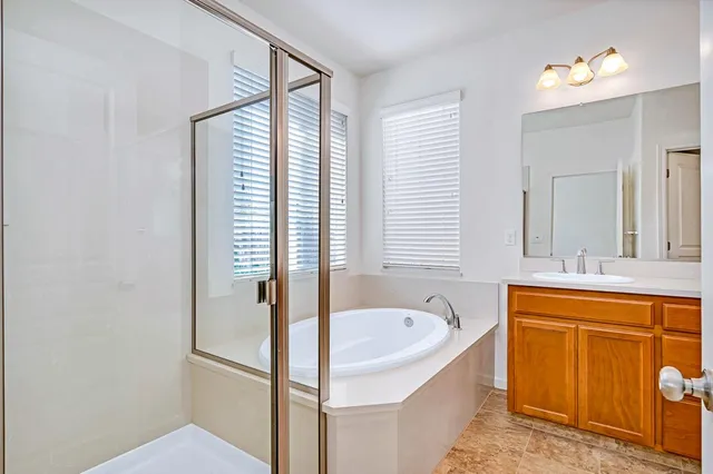 a bathroom with a tub sink and mirror
