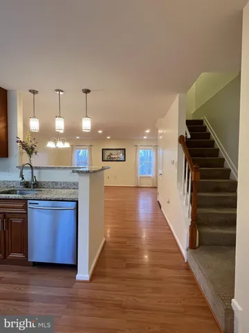 a kitchen with stainless steel appliances granite countertop a stove and a wooden floors