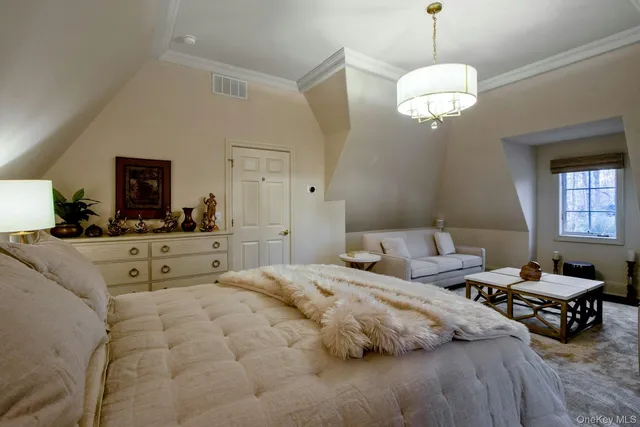 a spacious bedroom with a bed and a chandelier