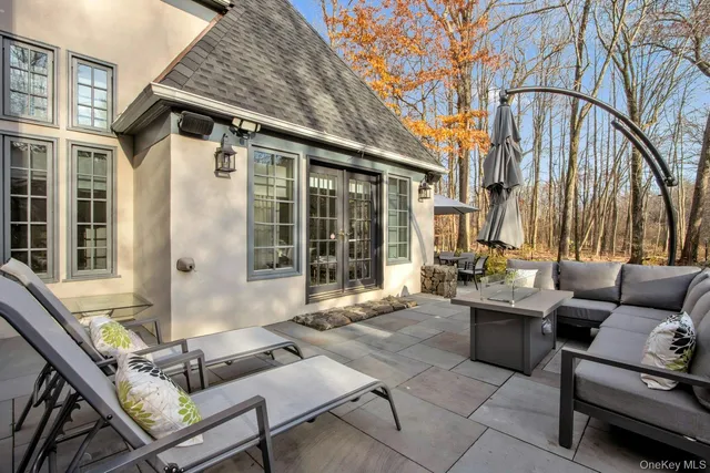 a view of a patio with couches table and chairs and potted plants