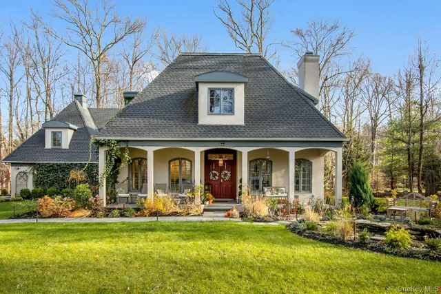 a front view of a house with swimming pool and porch with furniture