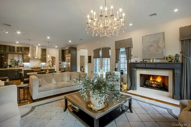 a living room with furniture a fireplace and a chandelier