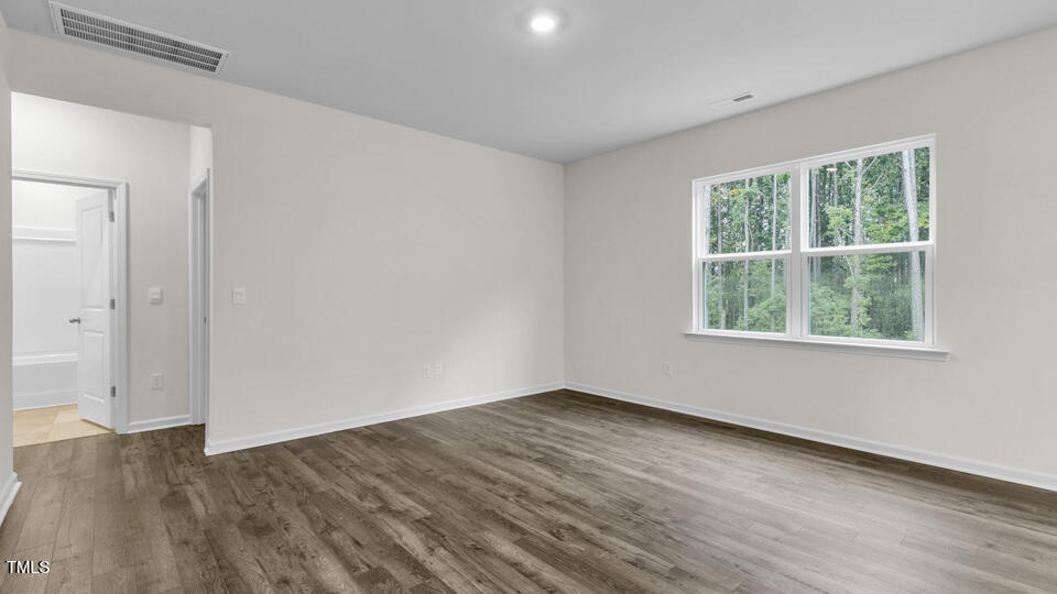 818 Comice Pear Way Willow Spring, NC 27592 - Photo 14 of 44 an empty room with wooden floor and windows