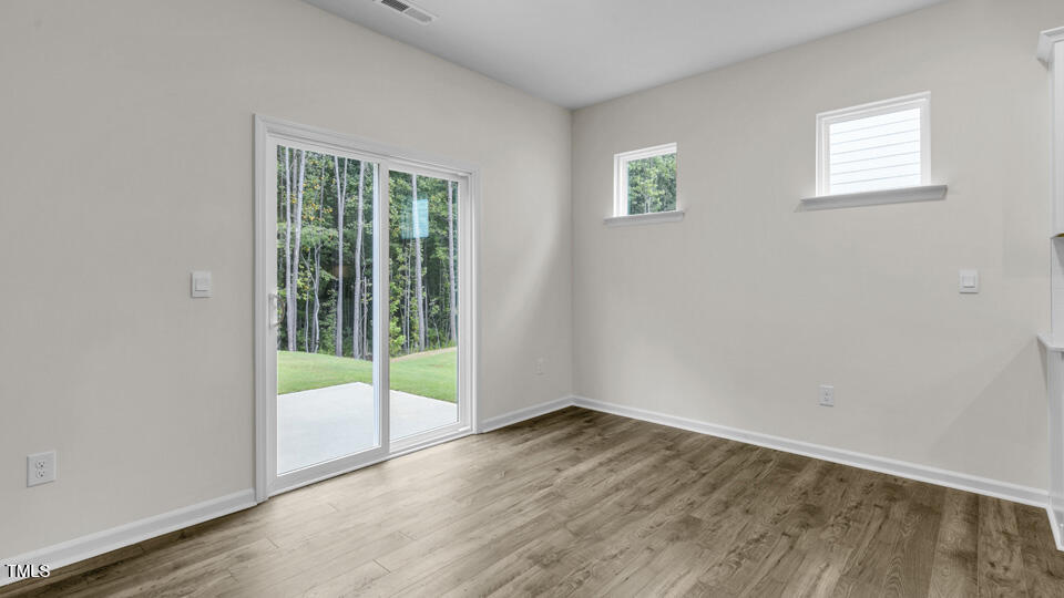 818 Comice Pear Way Willow Spring, NC 27592 - Photo 16 of 44 an empty room with wooden floor and windows