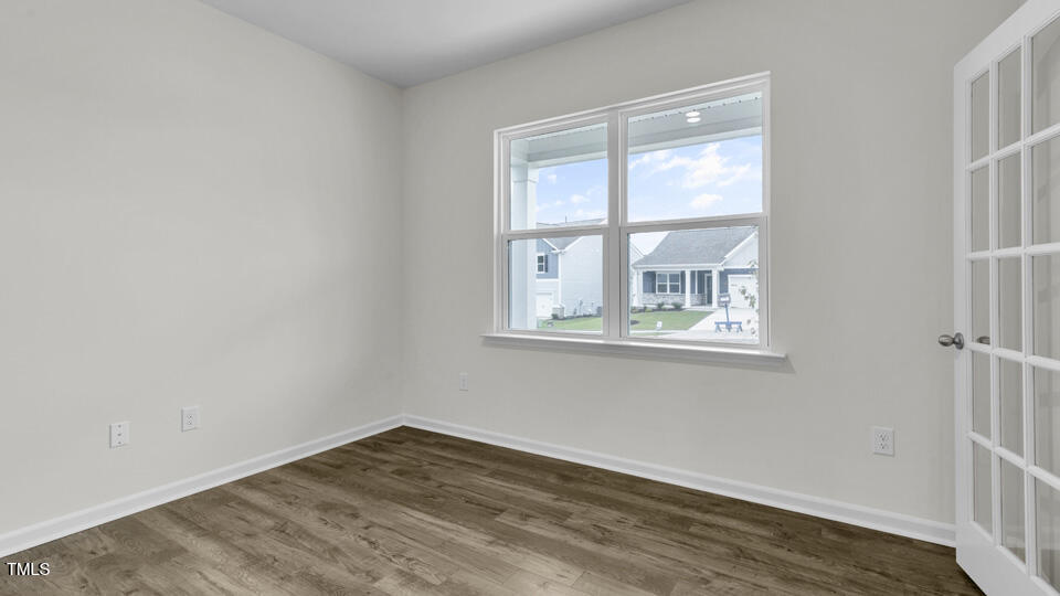 818 Comice Pear Way Willow Spring, NC 27592 - Photo 6 of 44 a view of an empty room with wooden floor and a window