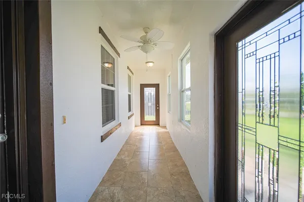 a view of a hallway with wooden floor and chandelier