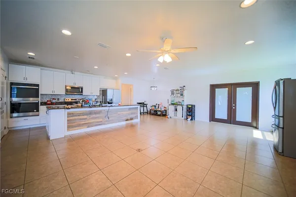 a dining hall with stainless steel appliances granite countertop a refrigerator and a stove top oven