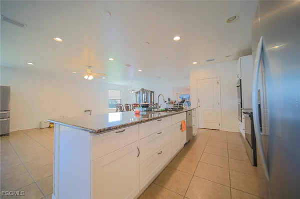 a kitchen with granite countertop white cabinets and stainless steel appliances