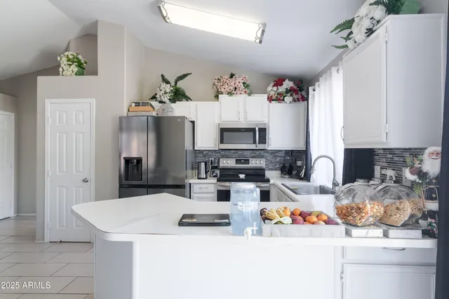 a kitchen with stainless steel appliances kitchen island granite countertop a sink a stove and a refrigerator