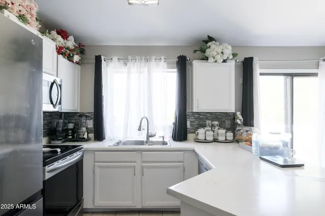 a kitchen with a sink appliances and cabinets