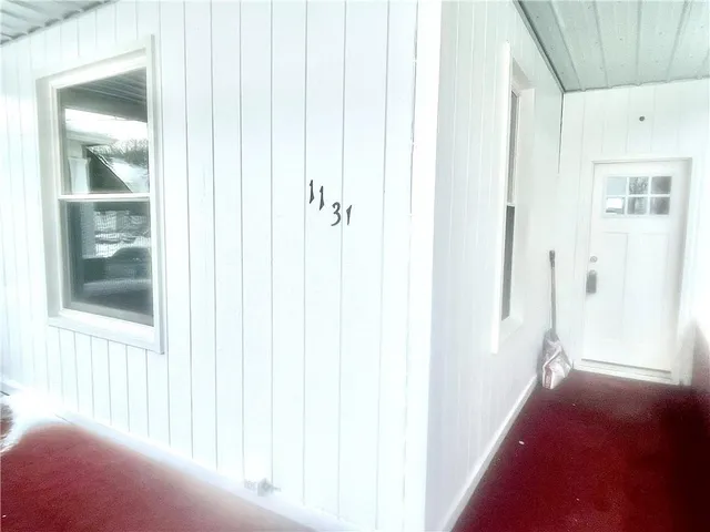 a view of a hallway with a window and a bathroom