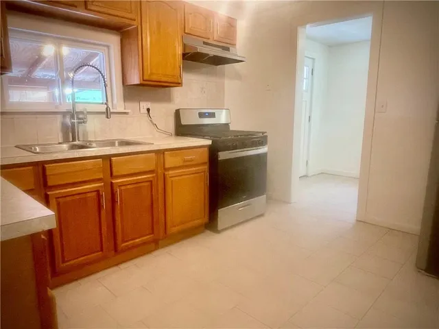 a kitchen with stainless steel appliances granite countertop a sink stove and cabinets