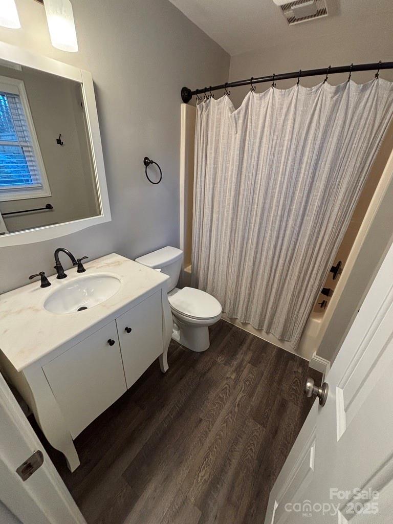 2411 Sutters Road Concord, NC 28027 - Photo 17 of 27 a bathroom with a sink a toilet a mirror and shower curtain