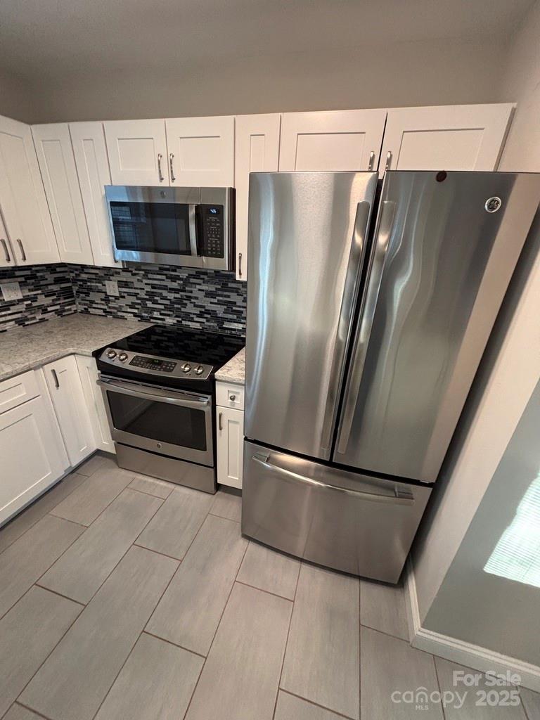 2411 Sutters Road Concord, NC 28027 - Photo 9 of 27 a kitchen with cabinets and stainless steel appliances