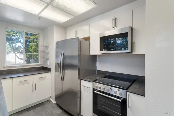 a kitchen with stainless steel appliances a stove a microwave and a refrigerator