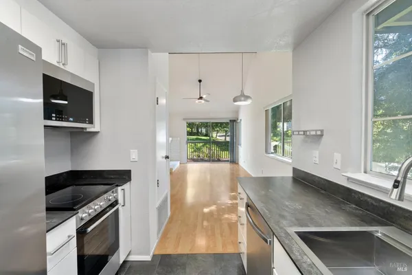 a kitchen with stainless steel appliances granite countertop a stove a sink and a microwave