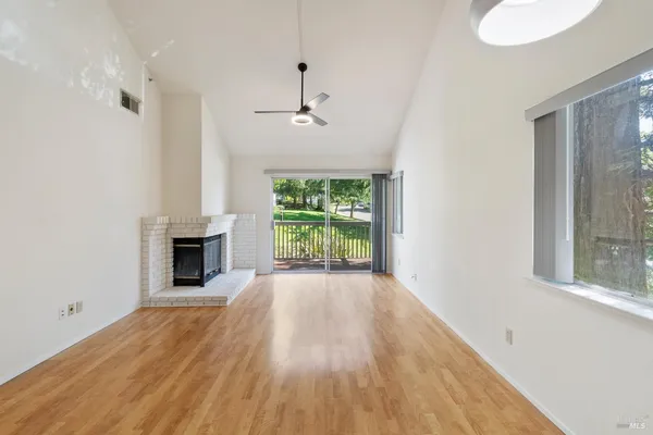 a view of empty room with wooden floor and fireplace