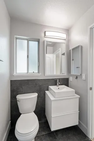 a bathroom with a sink mirror toilet and a window
