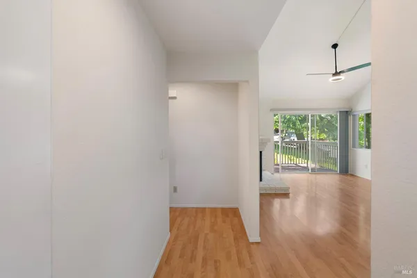 a view of an empty room with wooden floor and a window