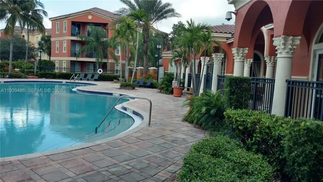 a front view of multi story residential apartment building with yard and sign board