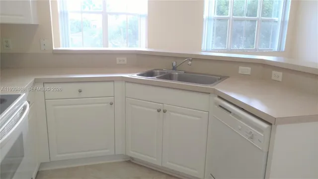 a kitchen with stainless steel appliances white cabinets and a window