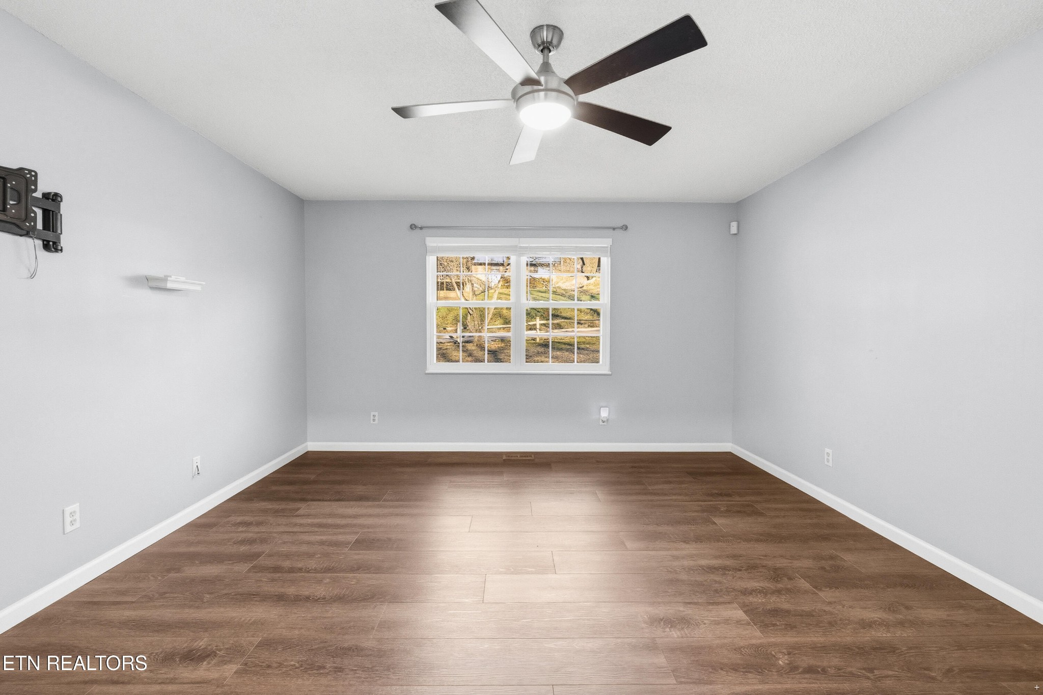 3214 Long Hollow Road Powell, TN 37849 - Photo 17 of 23 an empty room with wooden floor ceiling fan and windows