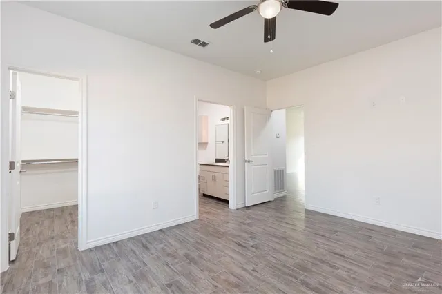 a view of empty room with wooden floor