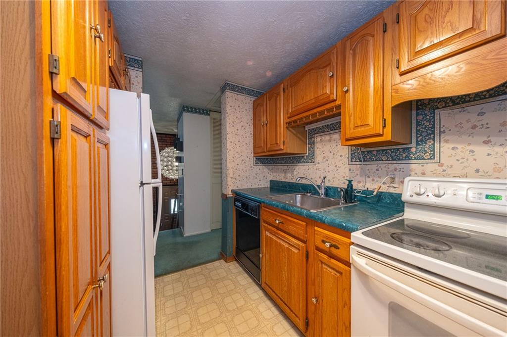 1310 Greenhill Rd Extension Pittsburgh, PA 15209 - Photo 14 of 39 a kitchen with stainless steel appliances granite countertop a stove a sink and a refrigerator