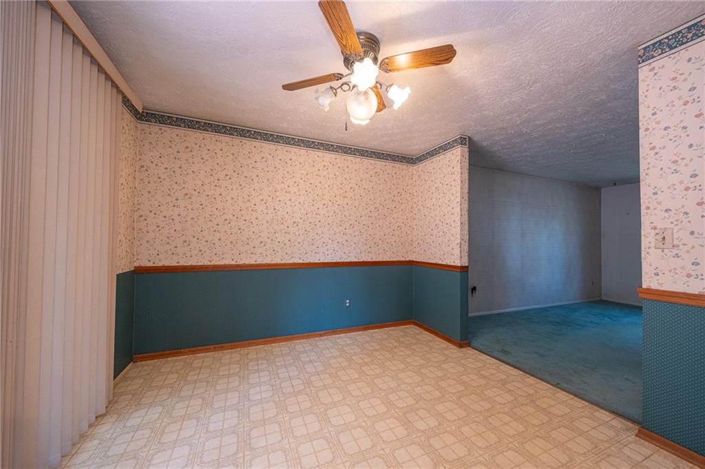 1310 Greenhill Rd Extension Pittsburgh, PA 15209 - Photo 5 of 39 an empty room with a chandelier fan and a window