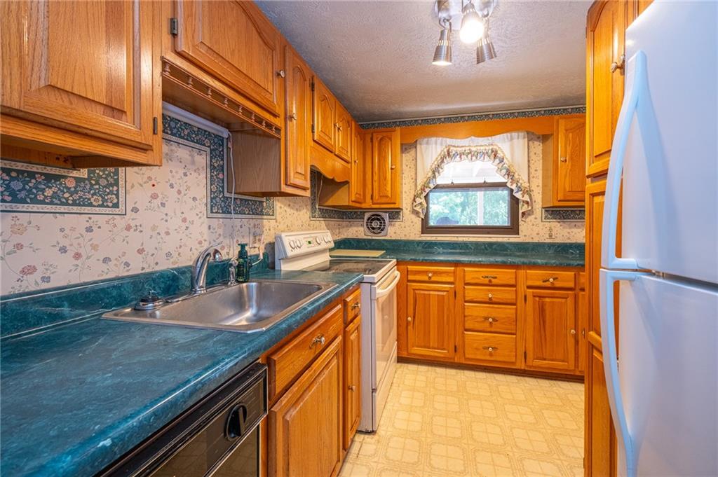 1310 Greenhill Rd Extension Pittsburgh, PA 15209 - Photo 6 of 39 a kitchen with granite countertop a sink a counter top space and cabinets