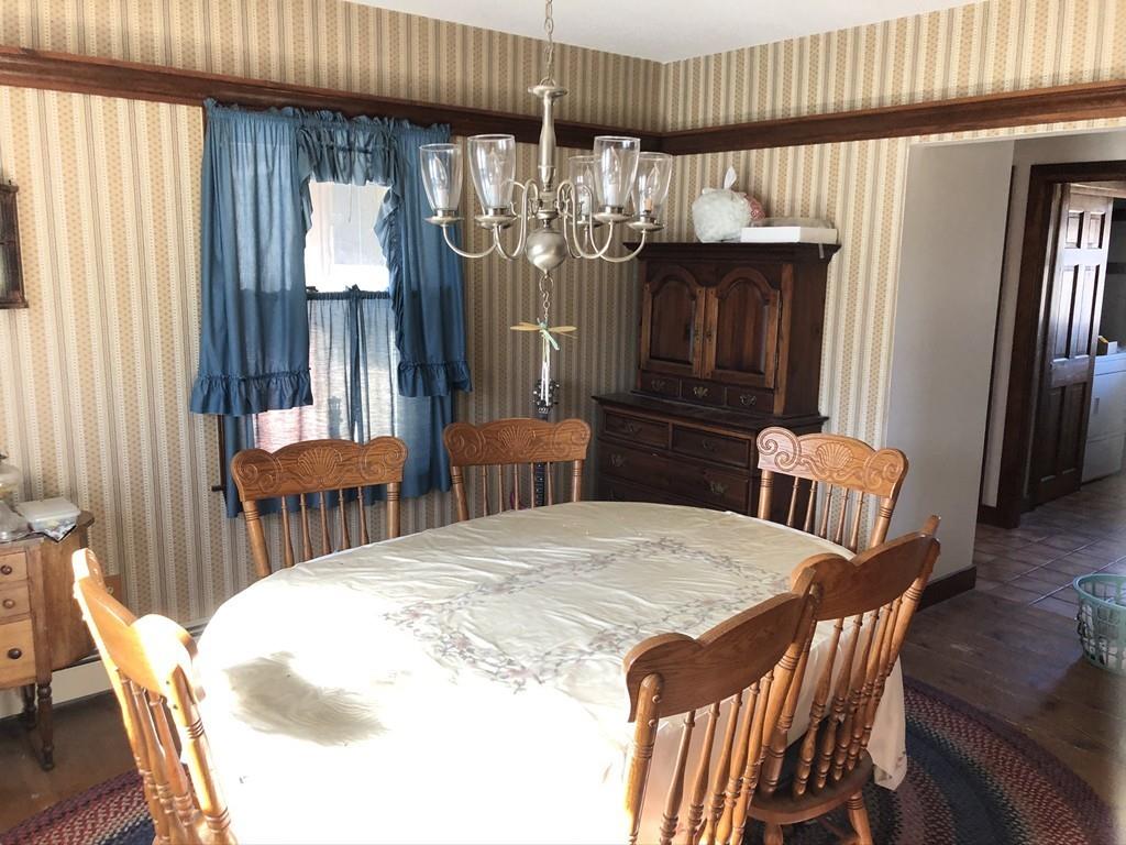 25 Long Boat Road Bourne, MA 02532 - Photo 7 of 23 a kitchen with granite countertop a refrigerator a stove a dining table and chairs with wooden floor
