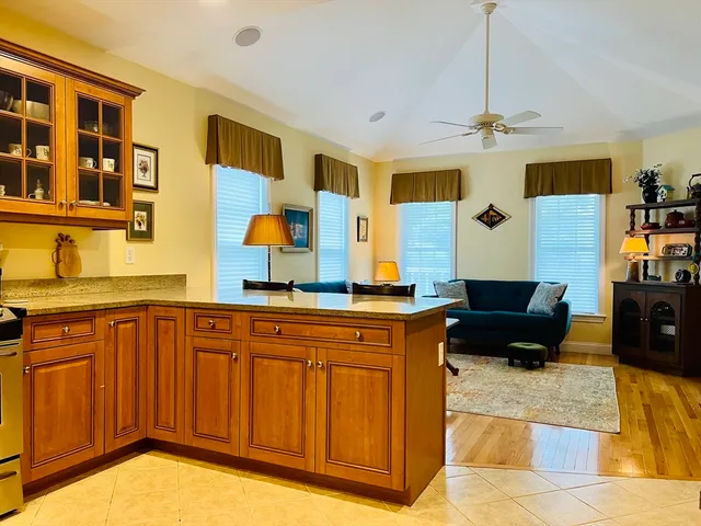 a living room with stainless steel appliances granite countertop furniture and a kitchen view