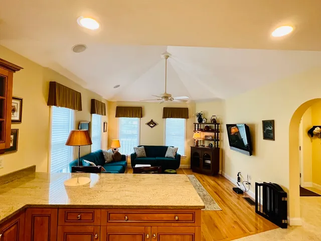a living room with stainless steel appliances kitchen island granite countertop furniture and a view of kitchen