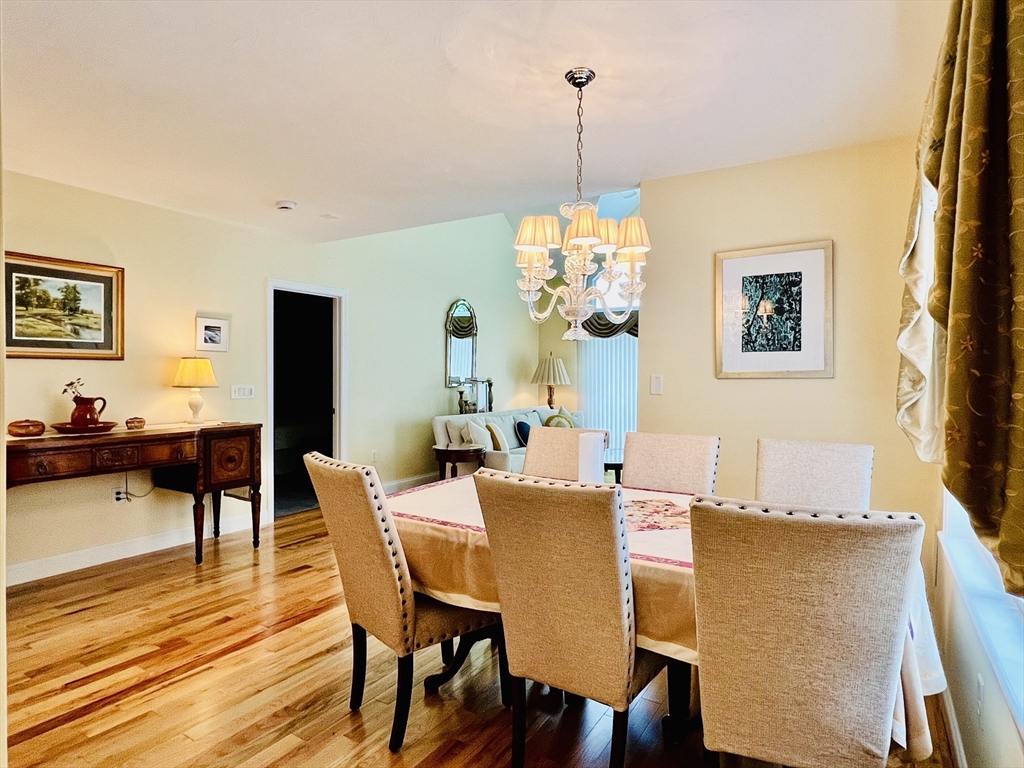 619 White Cliffs Drive, Unit 619 Plymouth, MA 02360 - Photo 23 of 42 a view of a dining room with furniture and wooden floor