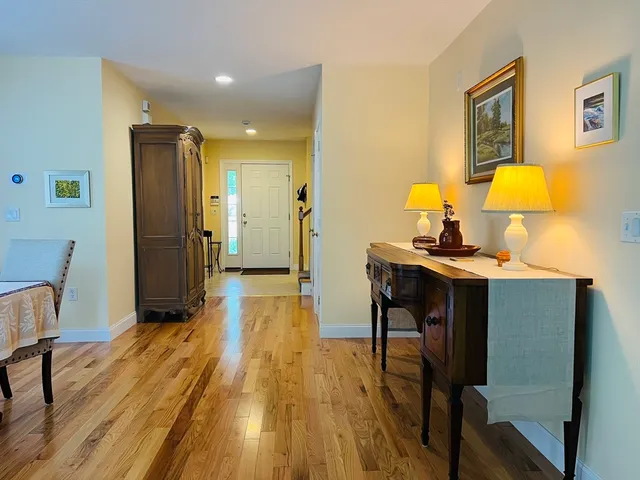 a bedroom with wooden floor and a table