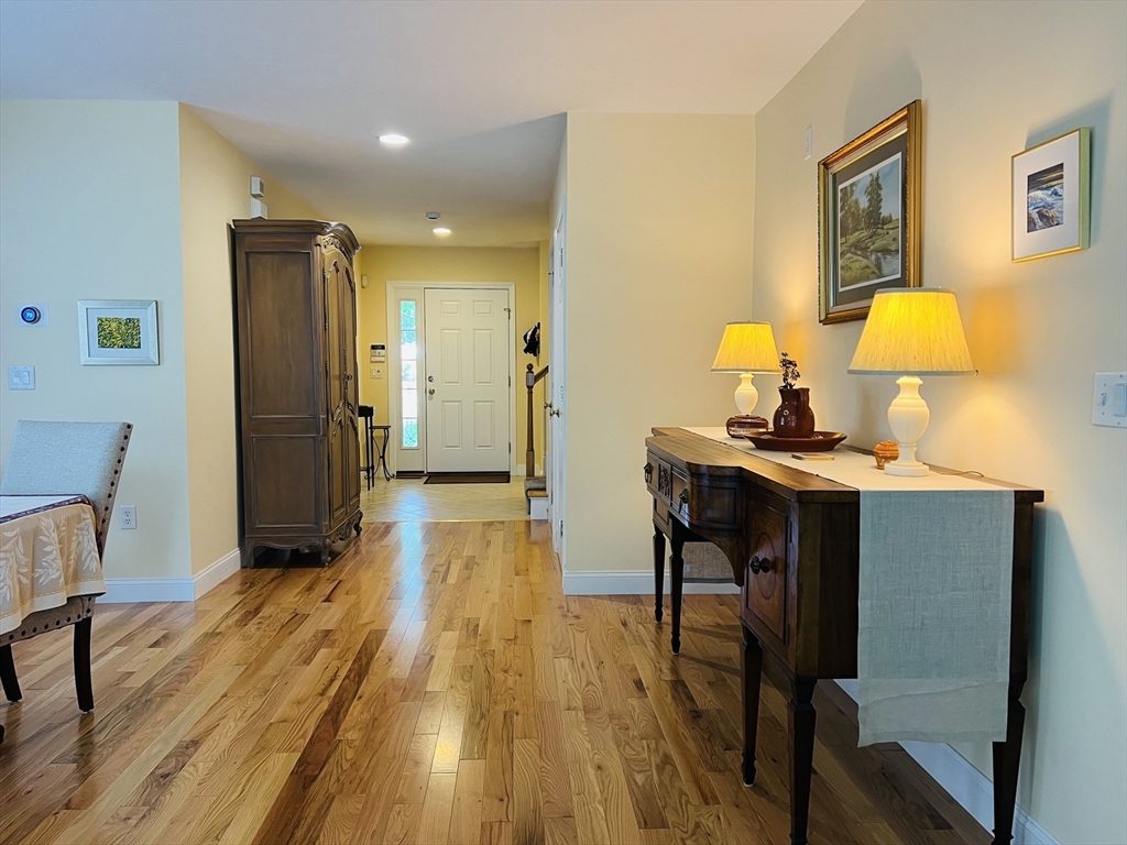 619 White Cliffs Drive, Unit 619 Plymouth, MA 02360 - Photo 28 of 42 a bedroom with wooden floor and a table