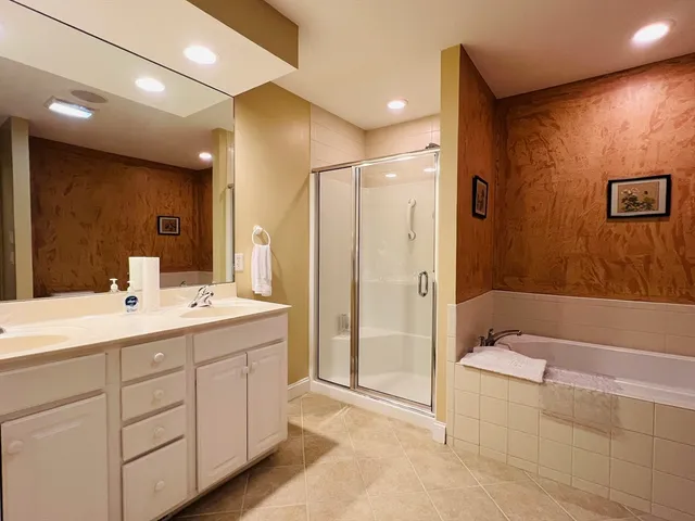 a bathroom with a double vanity sink mirror and shower