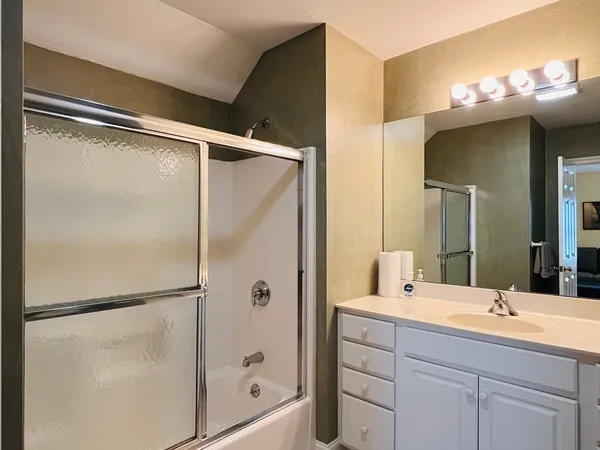 a bathroom with a double vanity sink mirror and shower