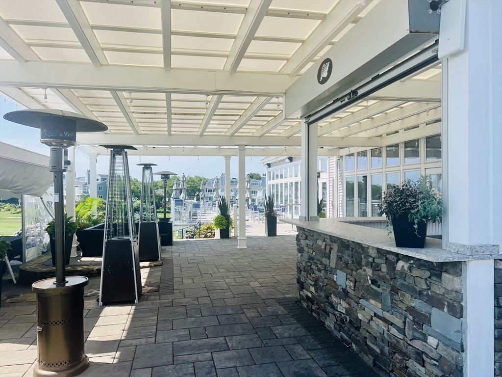 619 White Cliffs Drive, Unit 619 Plymouth, MA 02360 - Photo 5 of 42 a view of a porch with dining table and chairs