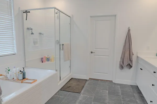 a bathroom with a tub shower vanity and a sink