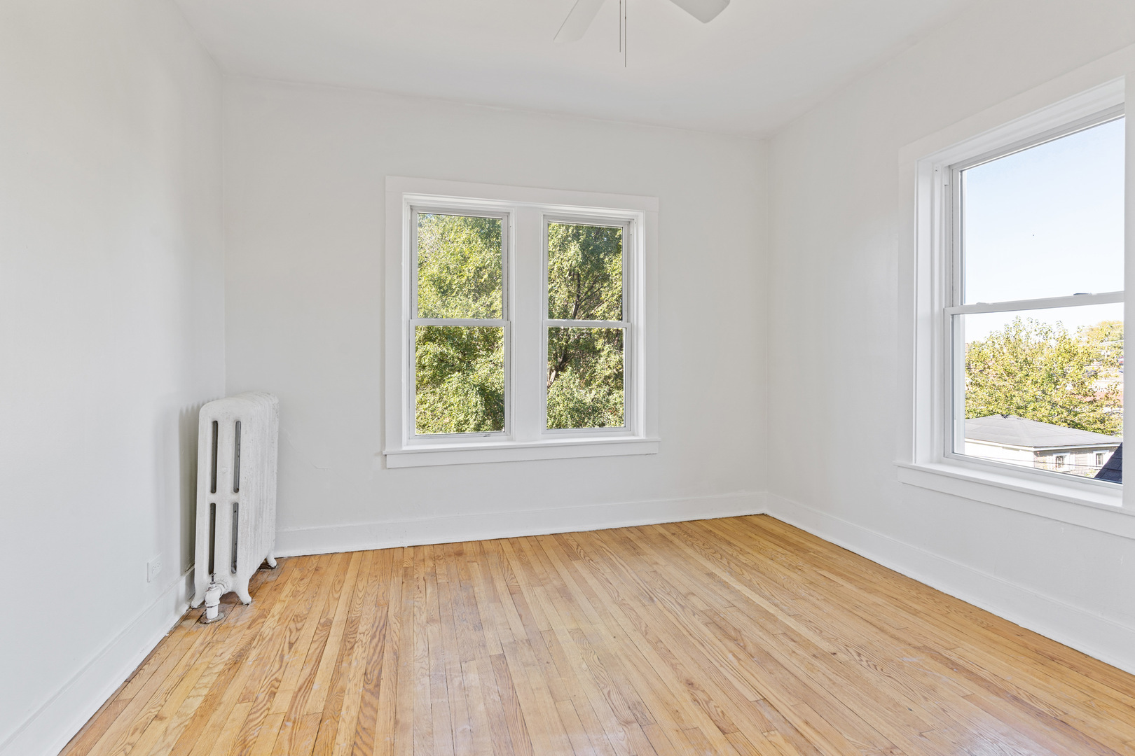 10342 South Calumet Avenue, Unit 3 Chicago, IL 60628 - Photo 14 of 25 an empty room with wooden floor and windows