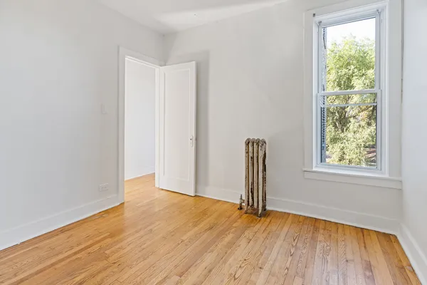 an empty room with wooden floor and a window