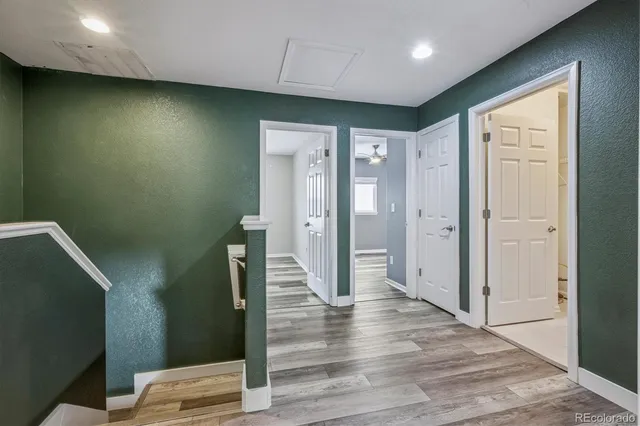 a view of a hallway with wooden floor and staircase