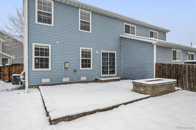 a backyard of a house with barbeque oven and wooden fence