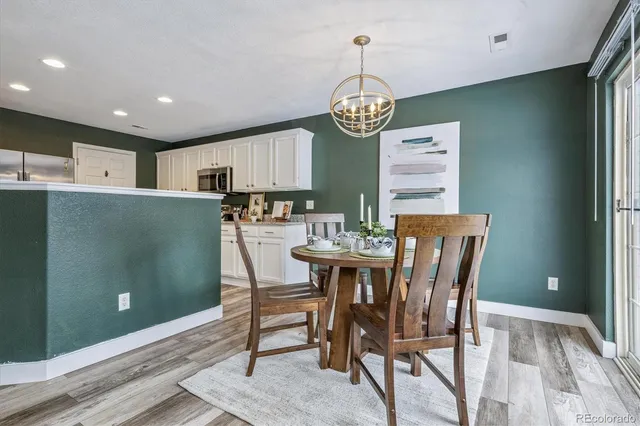 a view of a dining room with furniture wooden floor and chandelier