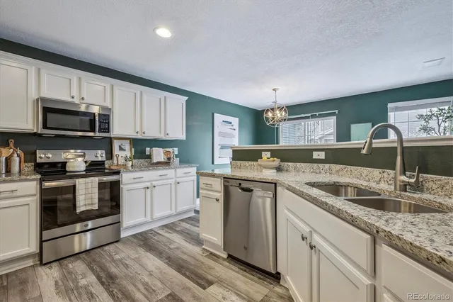 a kitchen with granite countertop a sink and steel appliances